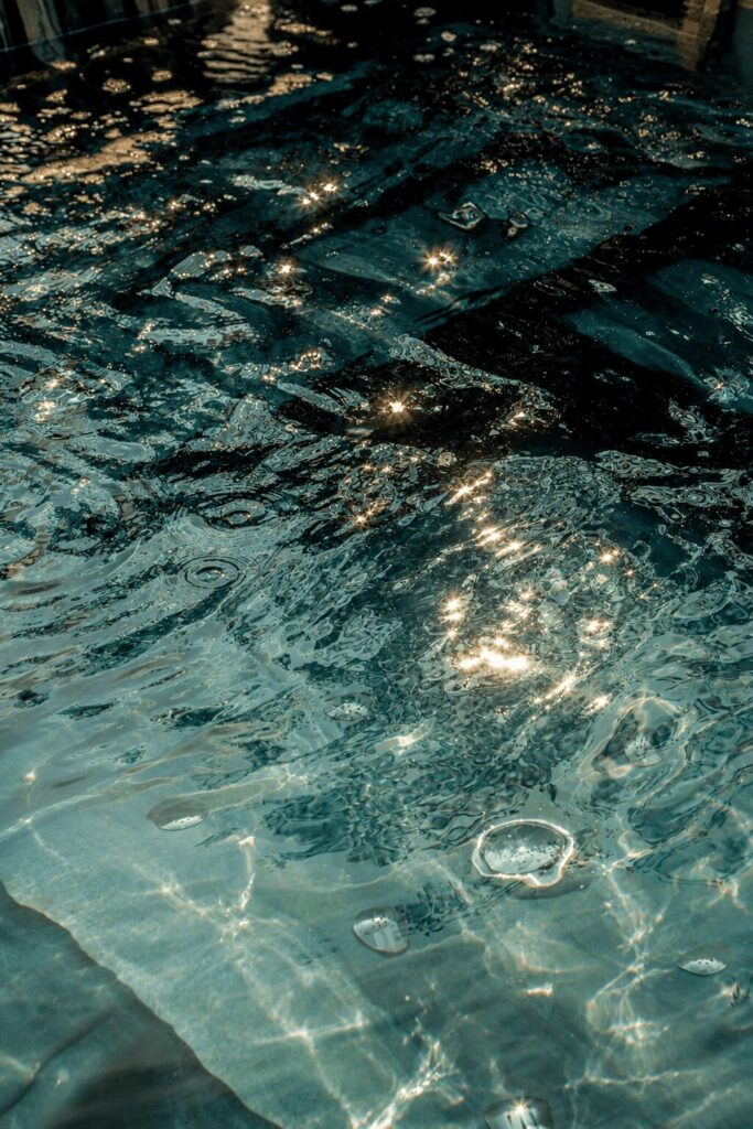 Dettaglio dell'acqua increspata della vasca, con riflessi di luce dorata sulla superficie